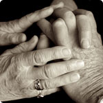 Two pairs of hands touching to offer comfort.