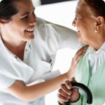 A community nurse helps an older lady.