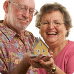 Man and woman with a model house in their hands.