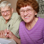 An older couple are filling in a form.