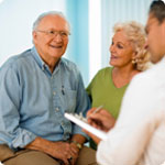 An older man and his wife are with the doctor.