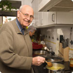 An older man preparing a meal.